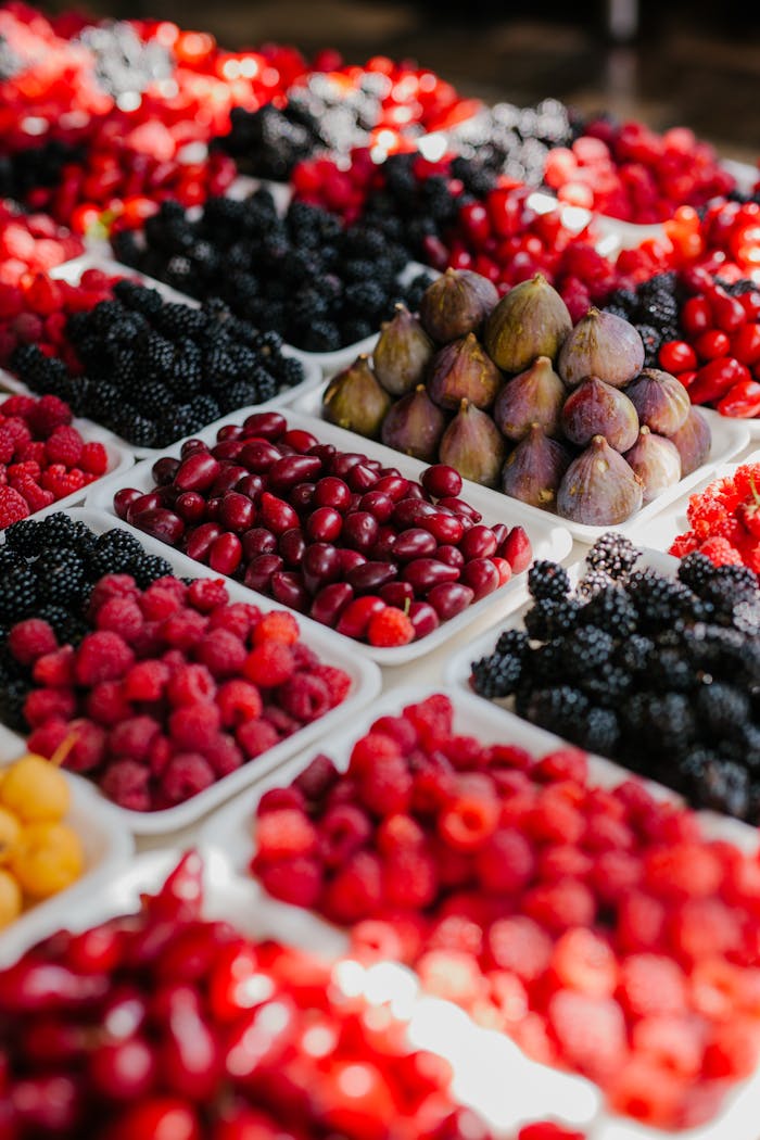 From above of assorted ripe blackberries figs raspberries and fruits of dog rose at counter